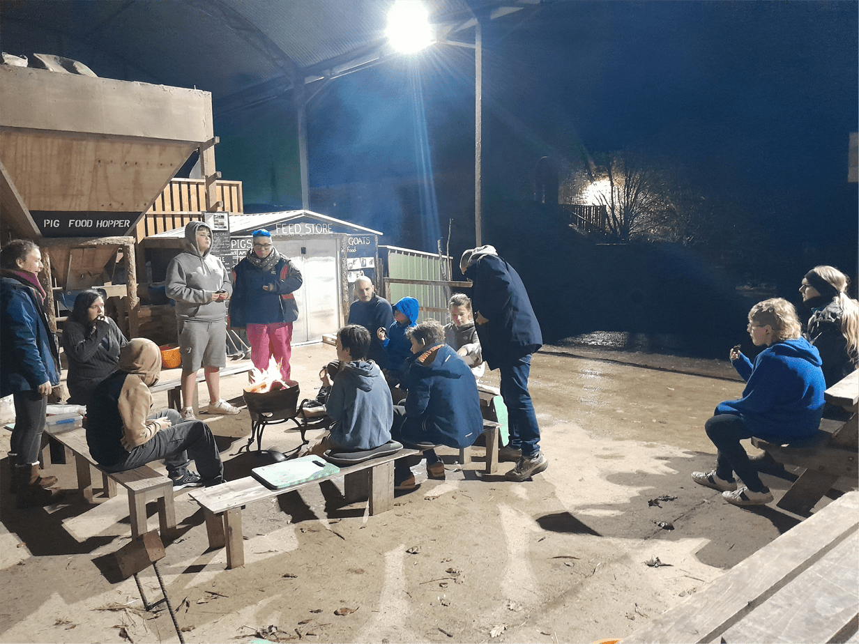 The Stable School learners enjoying an evening campfire during their residential trip at Magdalen Farm, Christchurch, Dorset.